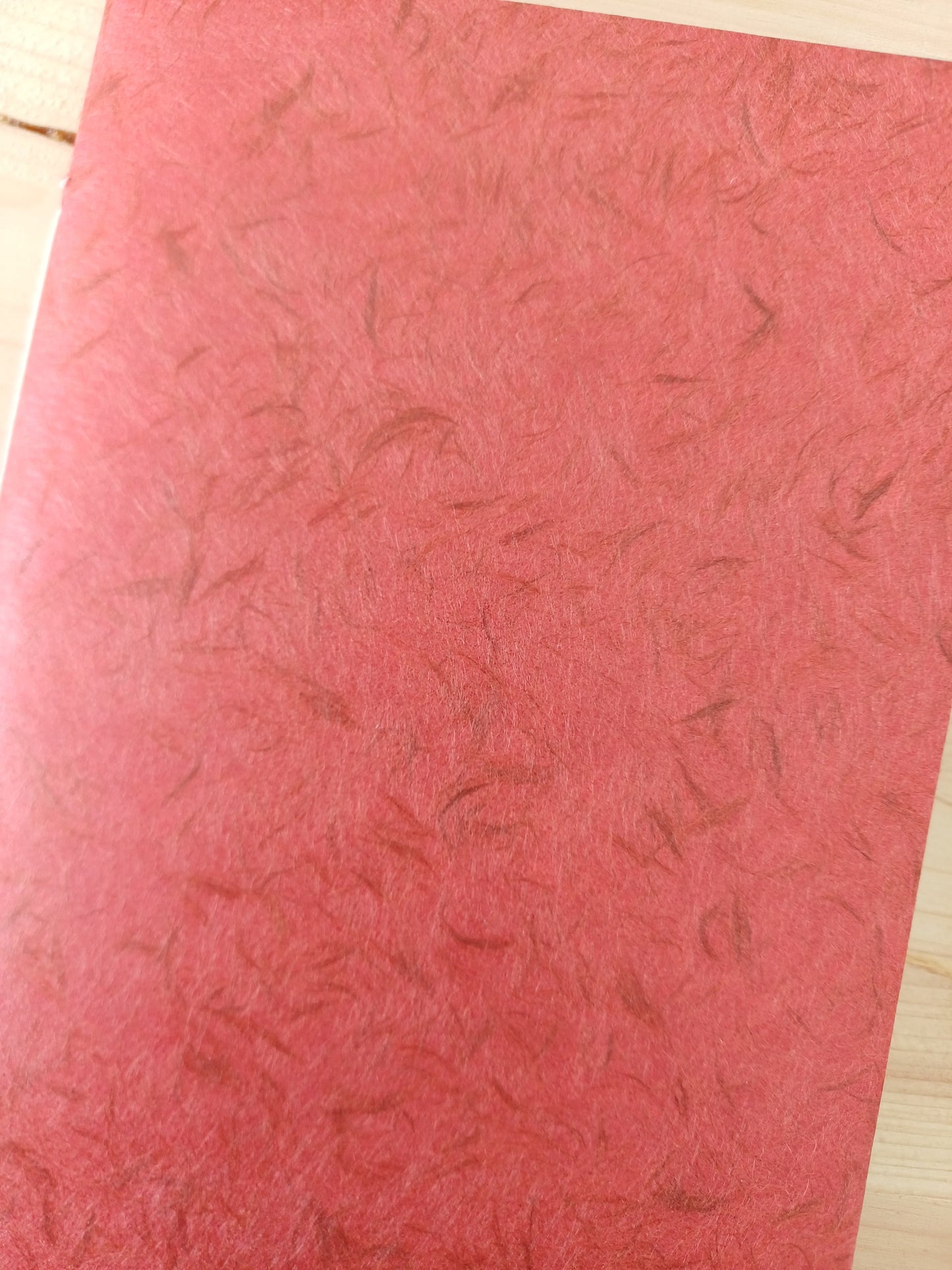 Petit carnet artisanal à la couverture de papier japonais obonai de couleur terracotta.