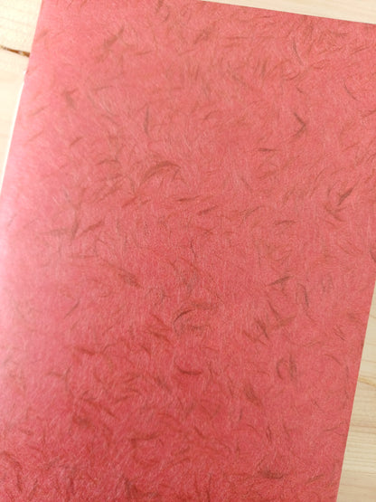 Petit carnet artisanal à la couverture de papier japonais obonai de couleur terracotta.