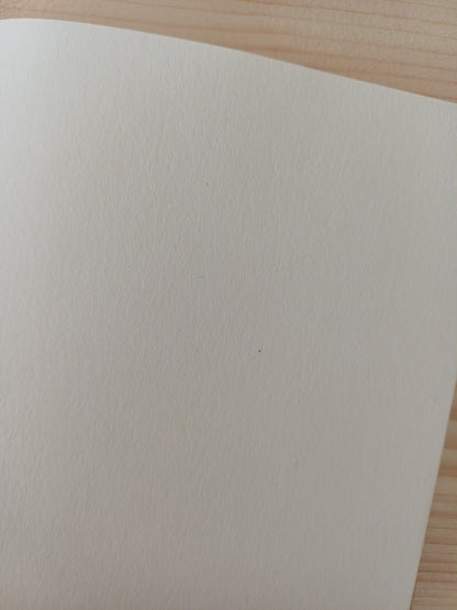 Détail d'une feuille de papier blanche d'un carnet artisanal.