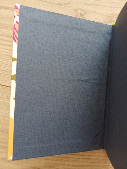 Garde d'un carnet artisanal de couleur bleue et le bord de la couverture aux motifs fleuris.