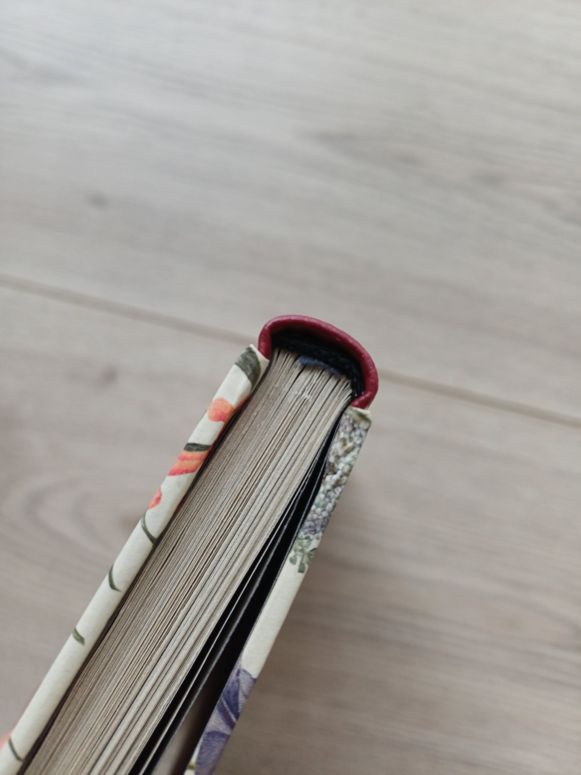 Vue sur la tranche fil d'un carnet artisanal.