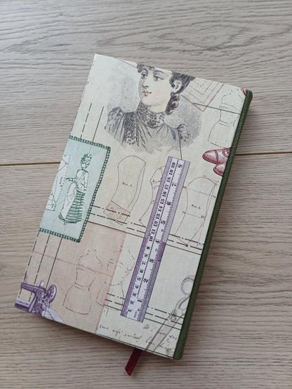 Carnet artisanal avec une couverture imprimée de motifs évoquant la couture : patrons, règles, mesures, modèles...