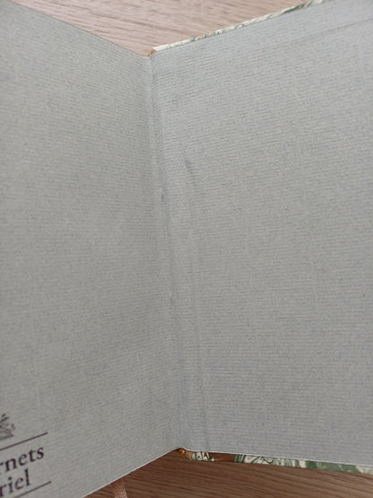 Carnet ouvert sur une page de garde dont on voit un défaut de collage.