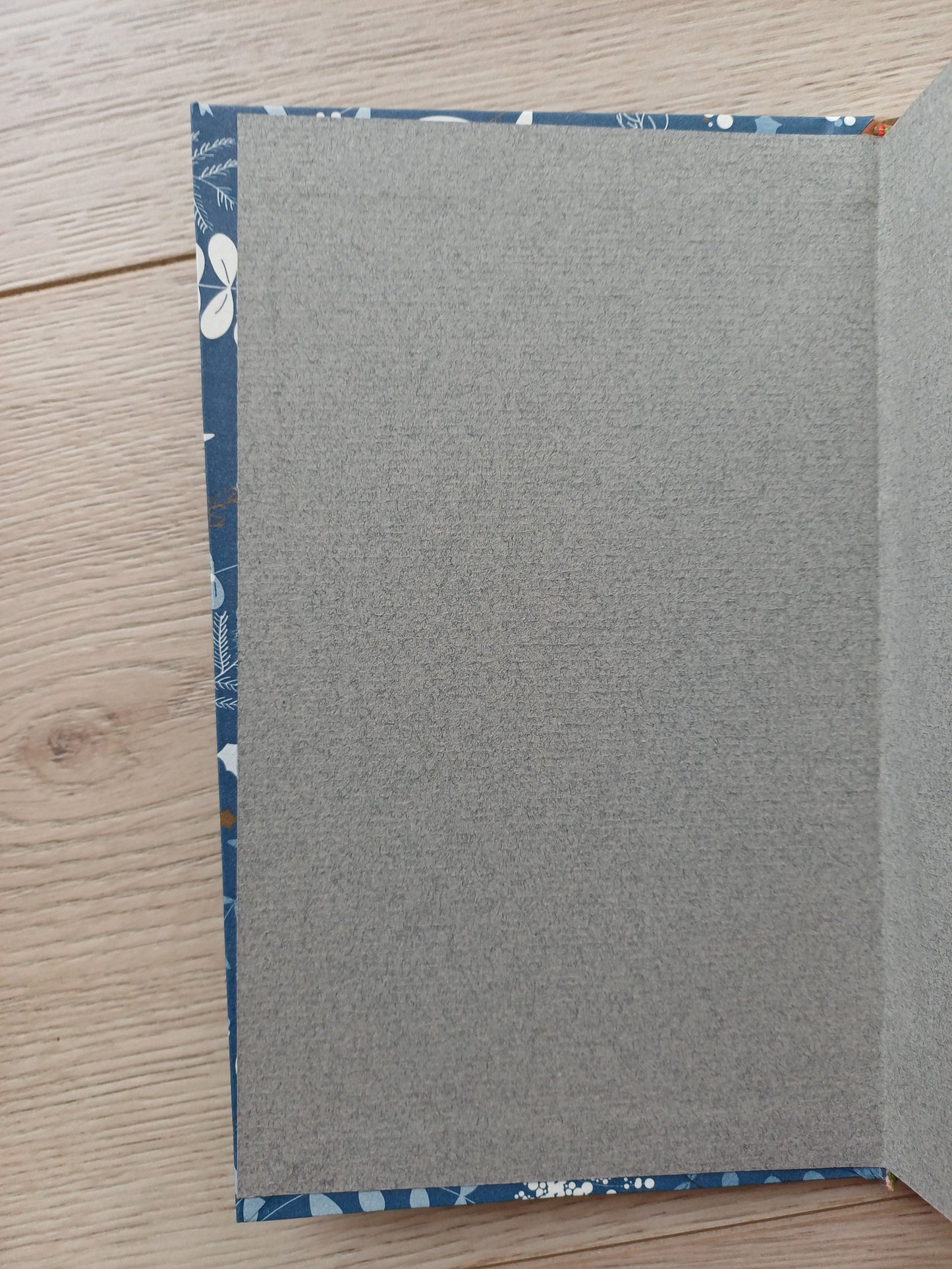 Carnet artisanal ouvert sur les pages de gardes collés légèrement de travers.