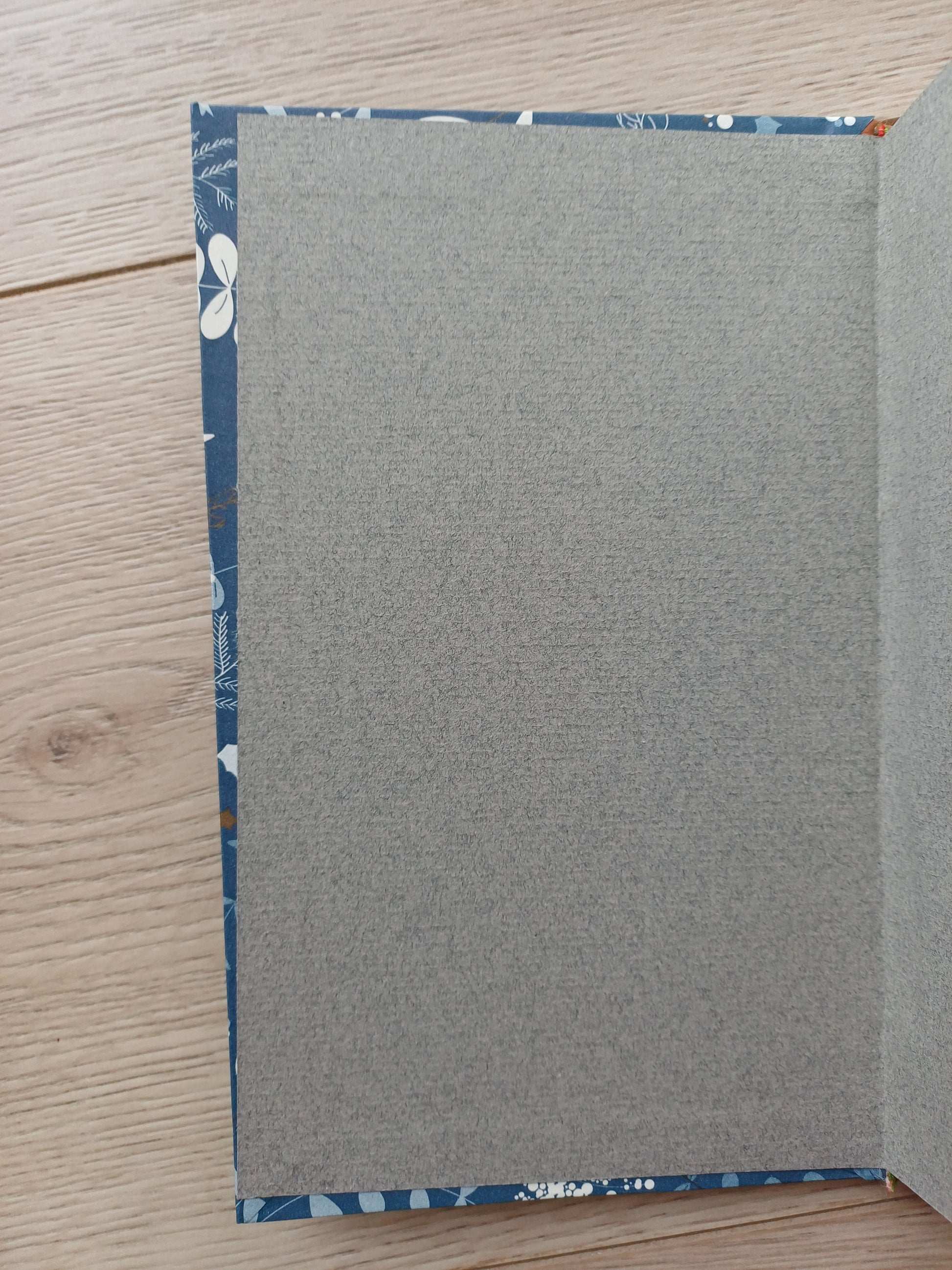 Carnet artisanal ouvert sur les pages de gardes collés légèrement de travers.