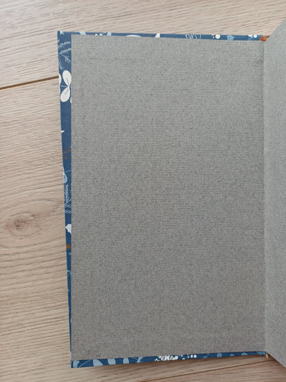 Carnet artisanal ouvert sur les pages de gardes collés légèrement de travers.