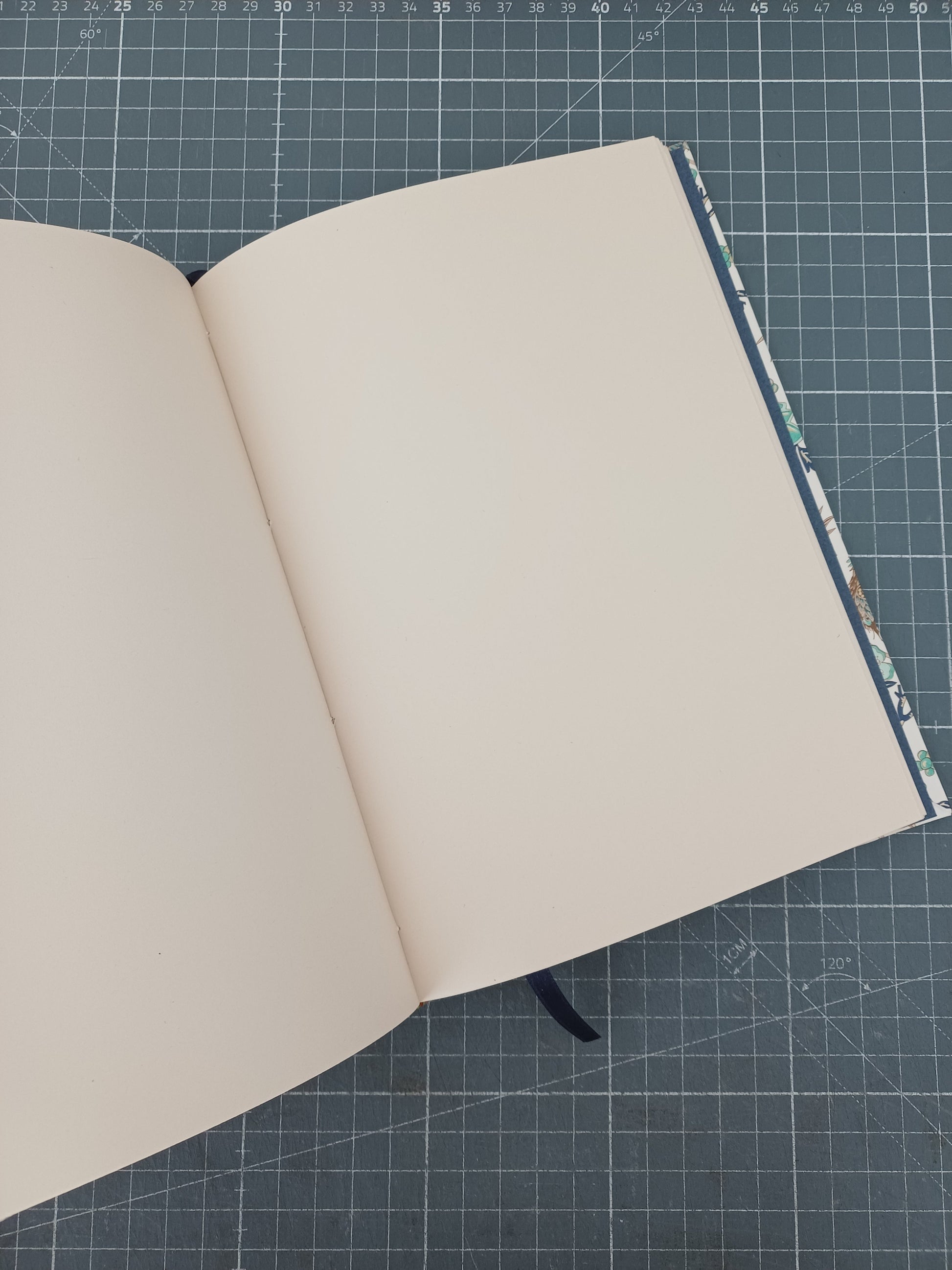 Carnet artisanal ouvert sur une page blanche.