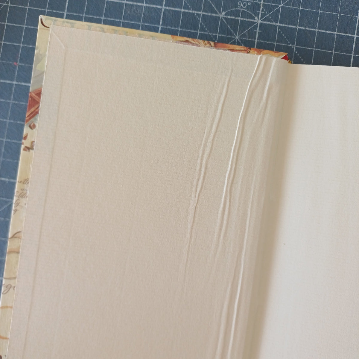 Page de garde beige d'un carnet artisanal avec des plis dus à un mauvais collage.