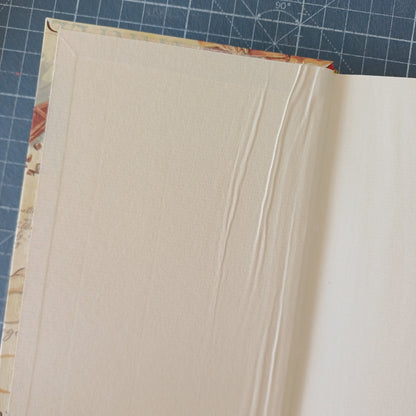 Page de garde beige d'un carnet artisanal avec des plis dus à un mauvais collage.
