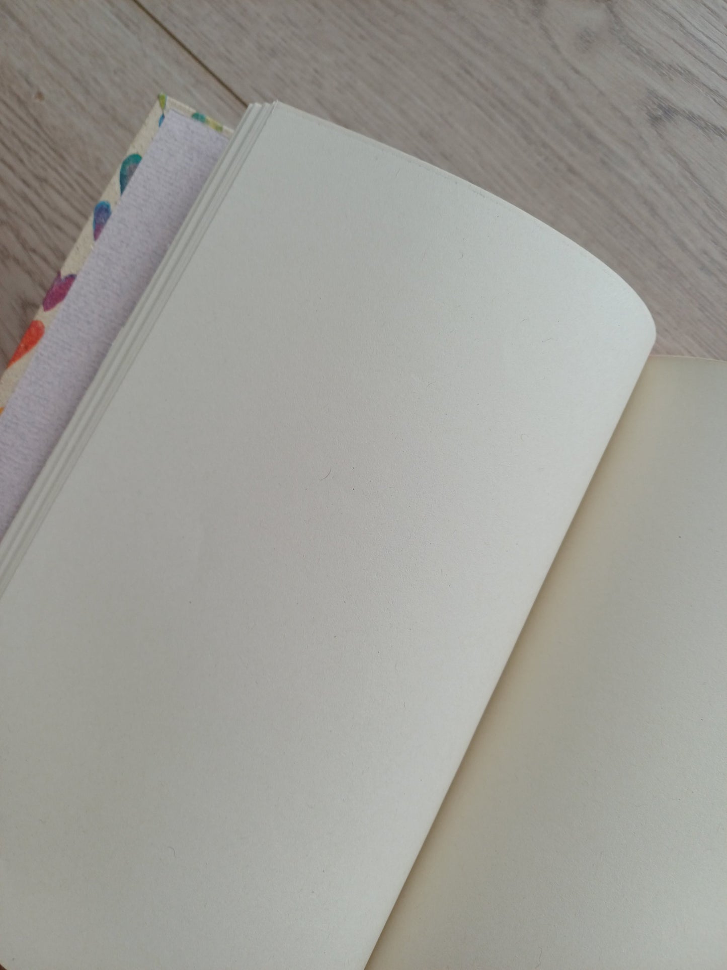Carnet ouvert sur des pages blanches où l'on peut voir les détails du papier intérieur.