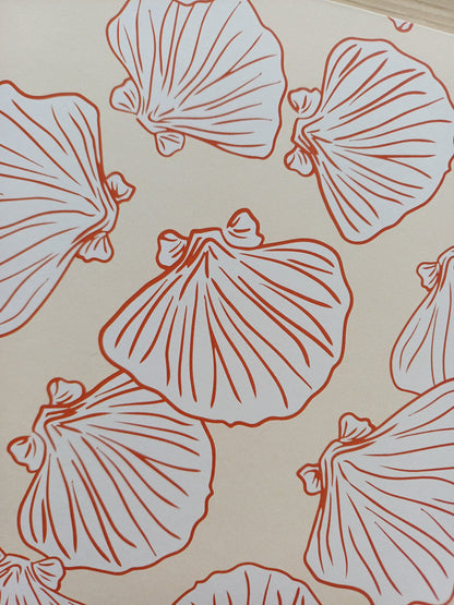 Détail de la couverture d'un carnet artisanal pour aquarelle avec des motifs de coquillages terracotta sur un fond beige.