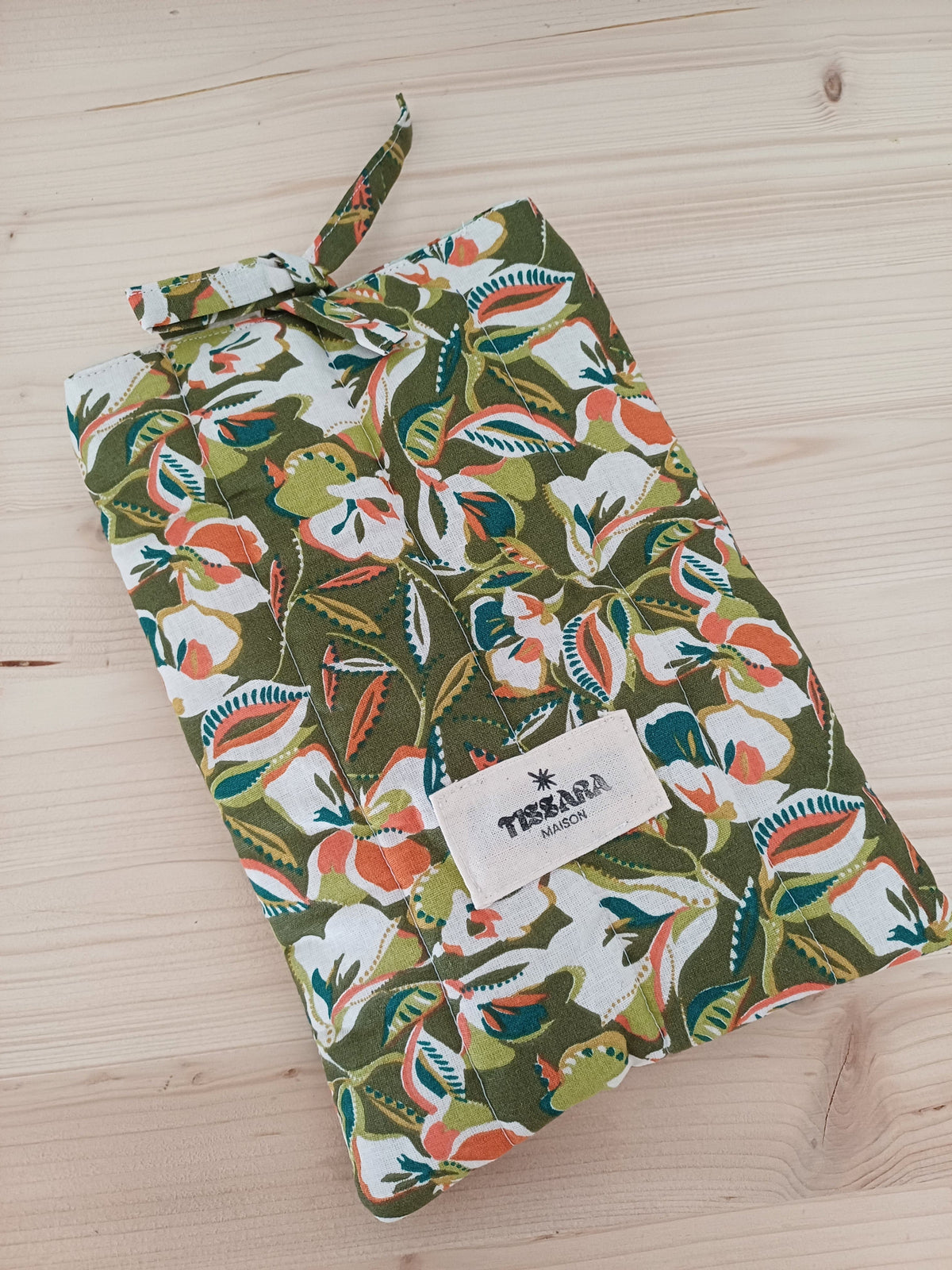 Pochette en tissu aux motifs floraux avec un ruban noué sur le sommet.